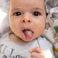 Baby streckt Zunge raus